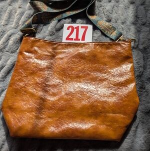 Lot 217 brown leather crossbody bag with a wide decorative strap
